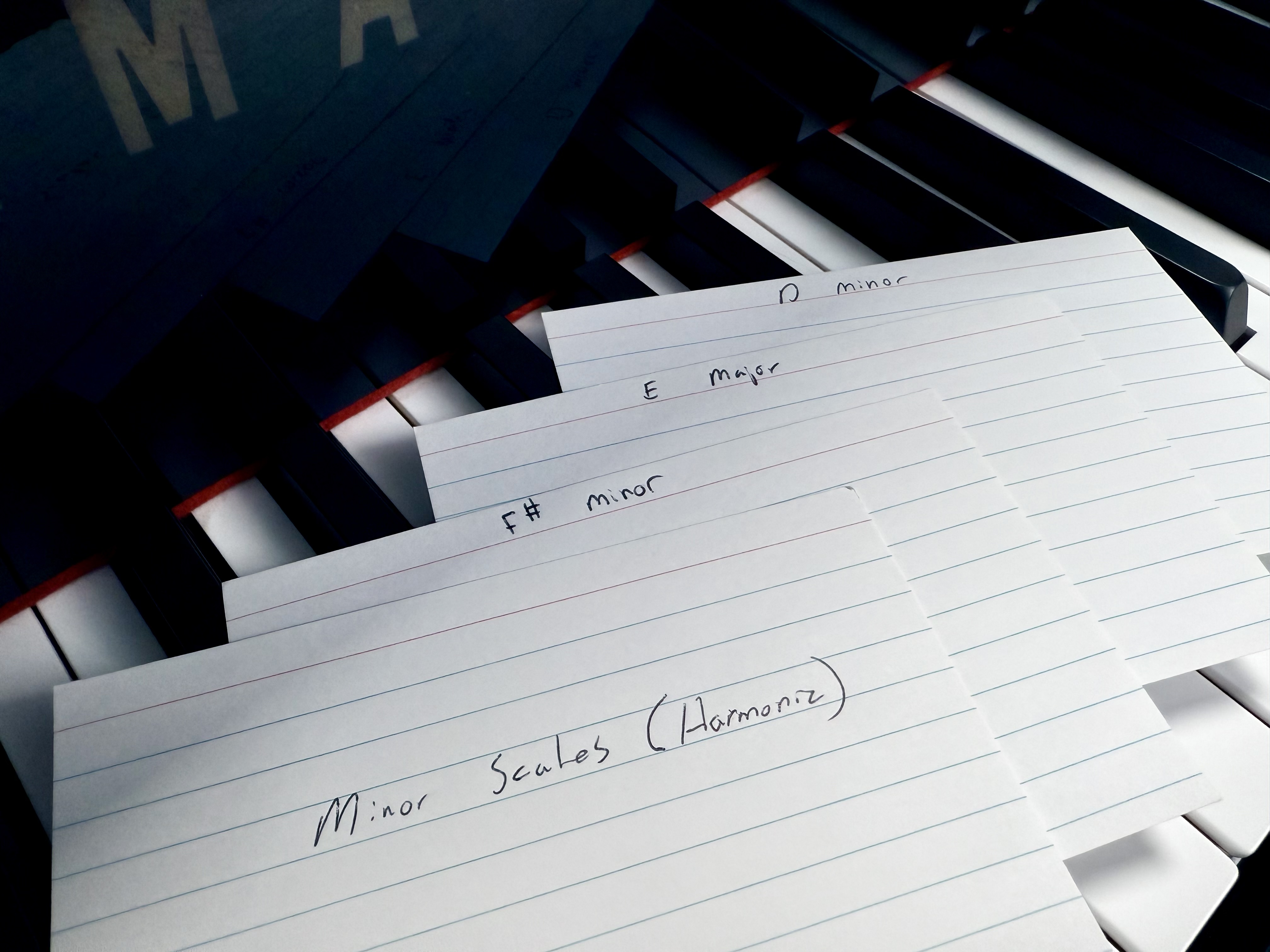 Flash cards with written key and exercise names laying on piano keys